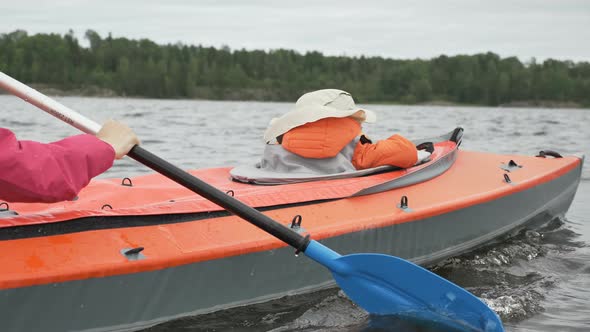 Little Child Sails in Kayak with Happy Mother on Large Lake