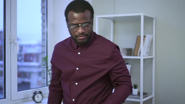 African Businessman Working at Window at Computer in American Office Spbas