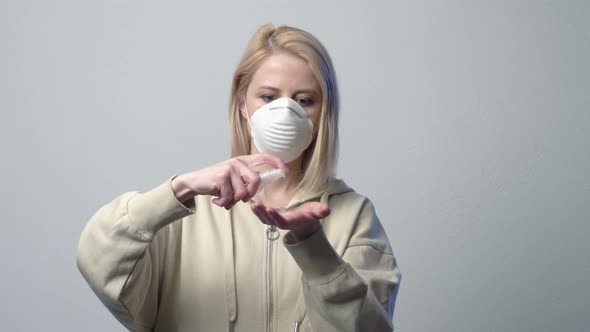 Blonde woman in protective mask with disinfection gel