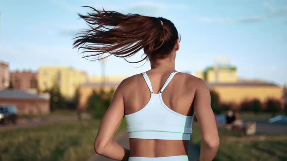 Active Runner Woman Practicing Morning Outdoor Cardio Physical Activity at City Street Back View