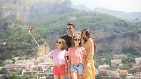 Parents and Kids Taking Selfie Photo Background Positano Town in Itali on Amalfi Coast