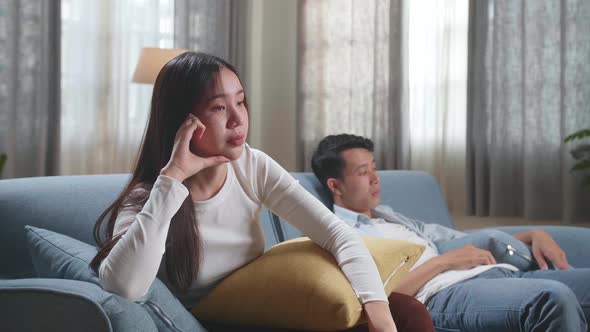 Young Asian Couple Are Watching Tv At Home With Sad Faces. Human Emotions And Television Concept