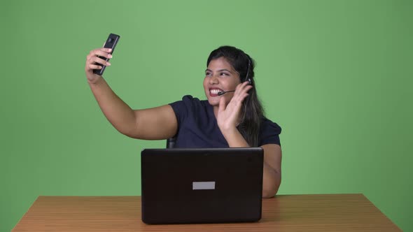 Young Overweight Beautiful Indian Businesswoman Against Green Background