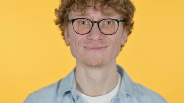 Close Up of Smiling Redhead Young Man on Yellow Background