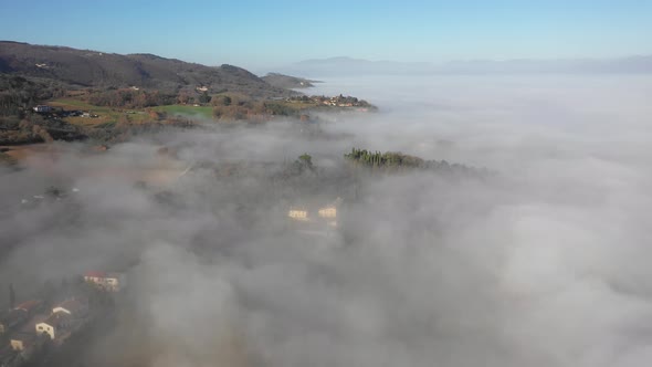 Aerial view of houses and fog at mountain in Umbria, Italy