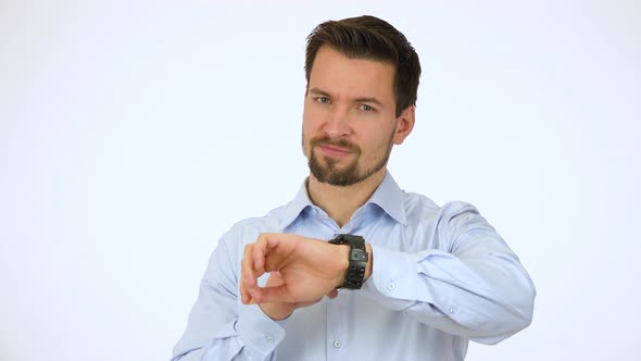 A Young Handsome Man Looks at the Camera and Taps His Watch Impatiently - White Screen Studio