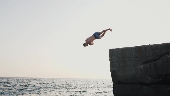 Young Man Jumping From Sea Pier and Doing Trick During Beautiful Sunrise Super Slow Motion