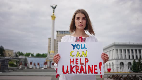 Woman in Embroidery Holds Poster Calling for Ukraine Support