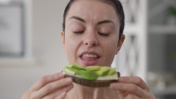 Headshot Portrait Young Slim Vegan Woman Biting Chewing Healthful Rye Bread Sandwich with Cucumber