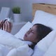 woman in casual clothing sleeping and wakes up to disable alarm clock. - VideoHive Item for Sale
