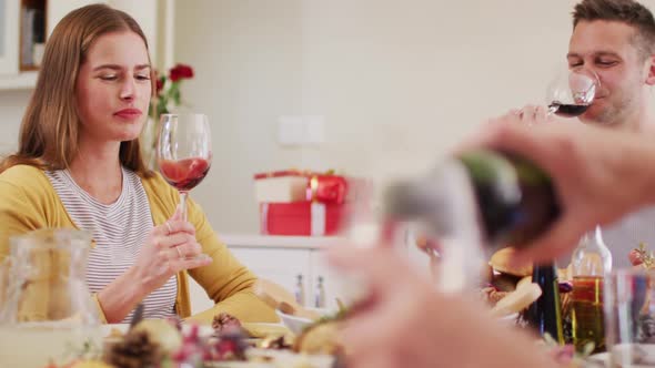 Caucasian family drinking wine while sitting by dining table