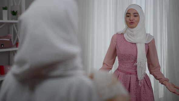 Portrait of Pretty Excited Young Middle Eastern Bridesmaid in Hijab Talking Gesturing As Blurred