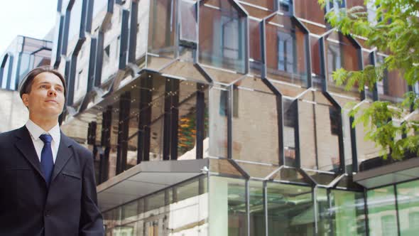 Confident businessman in front of modern office building. Financial investor outdoor.