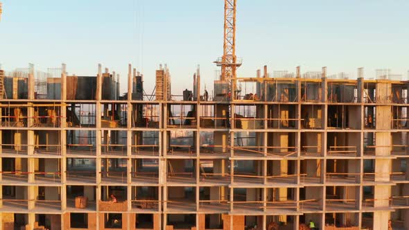 Aerial Shot of the Building in the Process of Construction. Labor Working in Big Construction Site