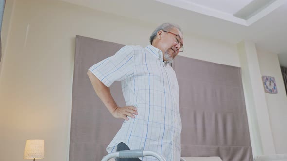 Asian Senior elderly disabled man patient walking slowly feeling painful and suffering from backache