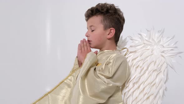 Baby Boy Praying He Has White Wings on a White Background
