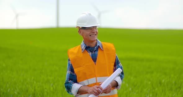 Male Engineer Working While Holding Blueprint