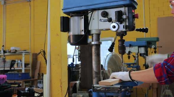 Pan view, Asian Carpenter checking wood before drill by drilling machine in workshop factory