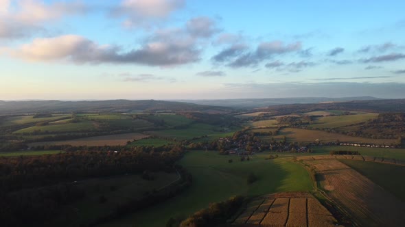 Aerial shot flying backwards over fields and farmland in Sussex, England