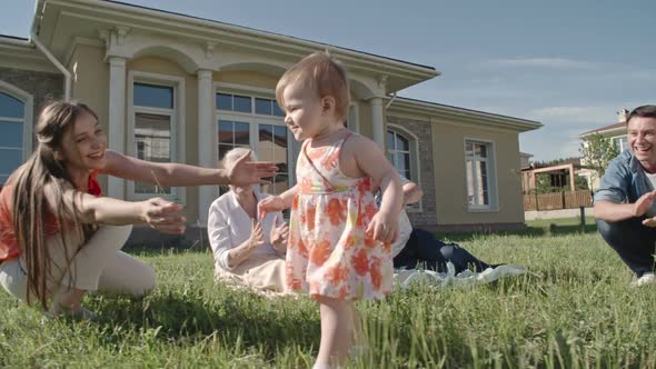 Proud Family Supporting Toddler Learning to Walk