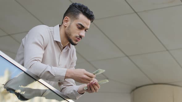 Young Arabian Hispanic Successful Business Man Counting Money Standing on Balcony Terrace