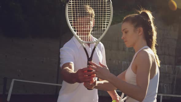 Woman and man playing tennis on a sunny day