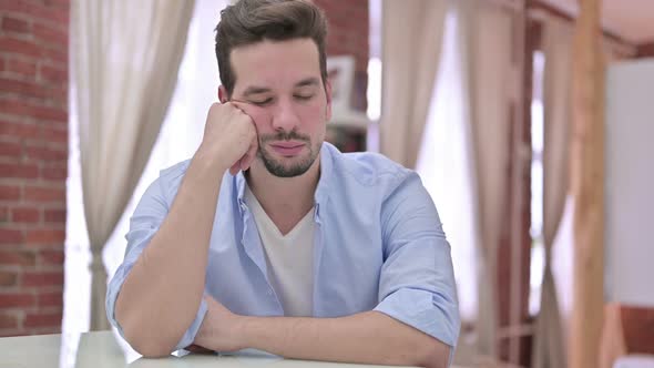 Sleepy Young Man Having Nap on Desk