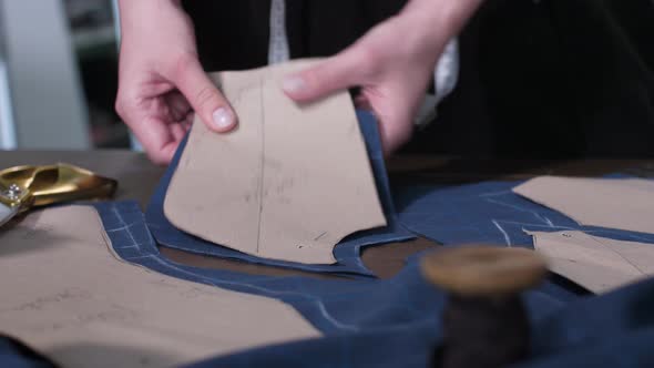 Female Hands Unpinning Paper From Cut Pattern