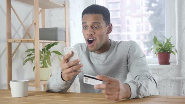 Online Shopping By Excited AfroAmerican Man Payment on Smartphone