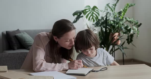 A Happy Mom Shows and Tells Her Son How to Solve a Difficult Math Example and Learn to Count and