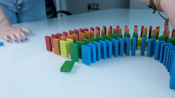 Line up of Dominoes in Rainbow Falling Colors with LGBT Colors of a Hand