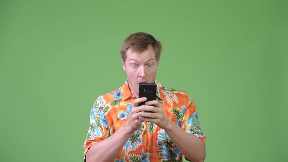 Young Handsome Tourist Man Using Phone and Looking Shocked