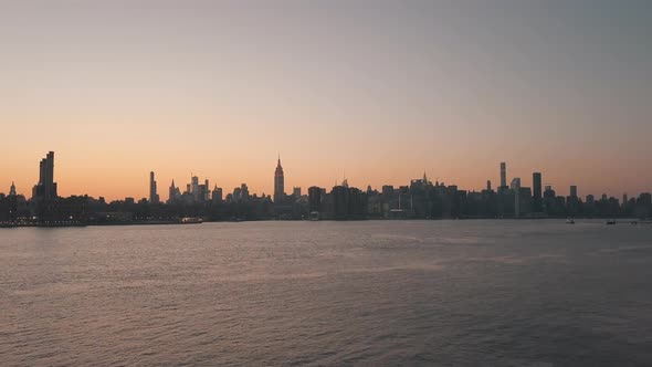 AERIAL: Gliding Over East River Overlooking Manhattan New York City Skyline in Beautiful Dawn Sunset