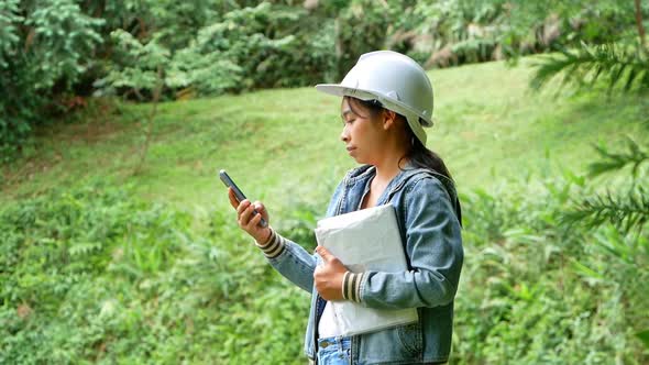 Female ecologist in safety hat working and controlling a quality of water