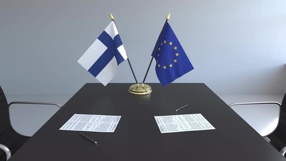 Flags of Finland and the EU and Papers on the Table