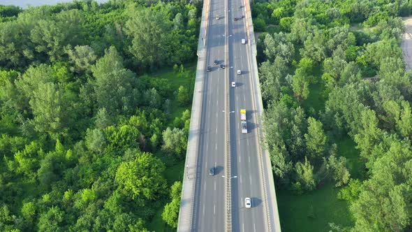 Aerial view of car traffic on modern bridge over river in city in summer day