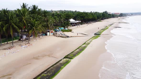 Aerial. Giant sandbag barricades on beach shore to prevent rising sea levels