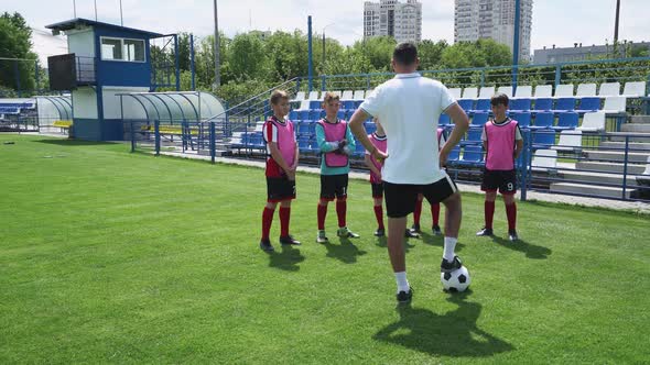 Young Team on the Training Football Field the Coach Instructs and Trains Young Players in Football