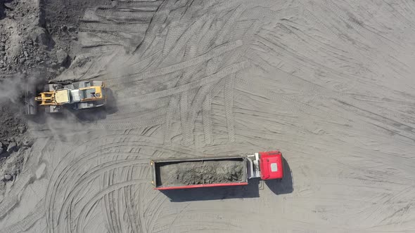 Aerial view loading bulldozer in open air quarry