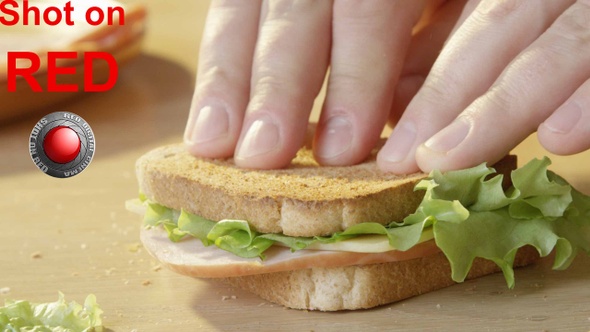 Making Ham And Cheese Sandwich With Lettuce And Toasted Bread On A Wooden Table