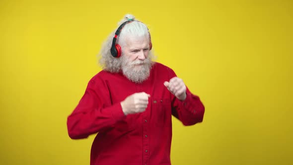 Active Senior Man in Headphones Listening To Music and Imitating Playing Drums