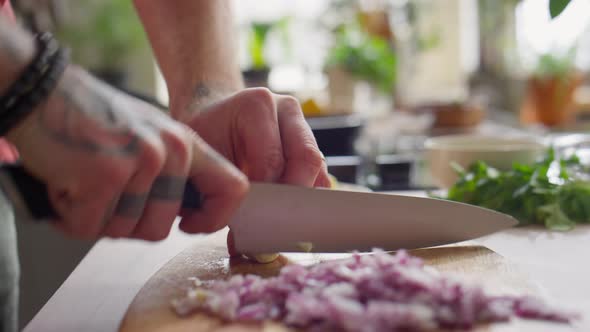 Hands of Chef Slicing Garlic