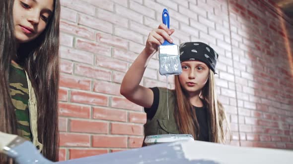 Girl Making Face Watching Paint Run Down Brush