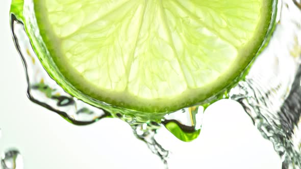 Super Slow Motion Macro Shot of Flowing Water From Lime Slice on White Background at 1000Fps