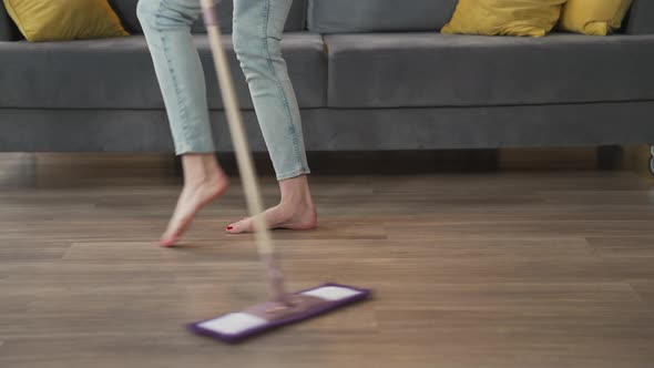 Young Woman Mopping the Floor and Dancing