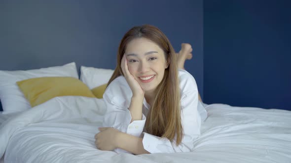 Portrait of beautiful attractive young woman smile and look at camera in cozy bedroom at home 