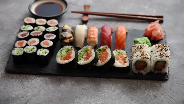 Composition of Different Kinds of Sushi Rolls Placed on Black Stone Board