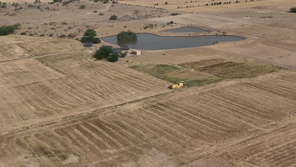 Aerial High Angle View Of Yellow Combine Harvester Working In Rural Punjab Field. Parallax Shot