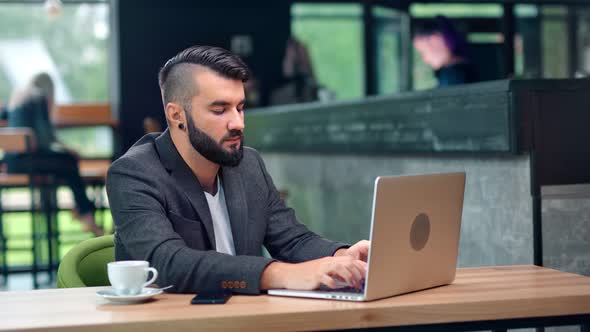 Attractive Male Freelancer Programmer Making Business Chatting Typing Using Laptop at Cozy Cafe