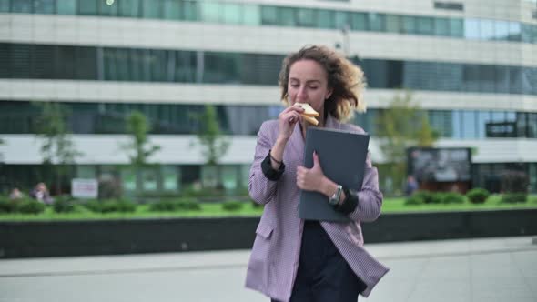 young woman is in a hurry on business and has a snack on the way